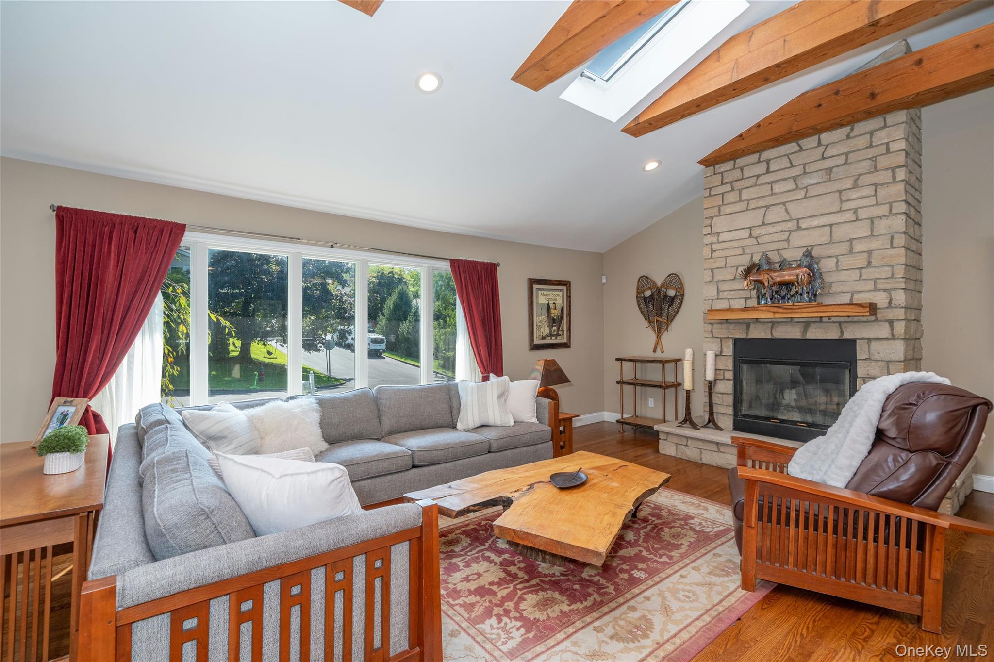 53 Tarryhill Road Tarrytown, NY 10591 - Photo 13 of 35 The stone fireplace creates a striking focal point in the living room, complemented by warm wood details and the home's distinctive exposed beams.