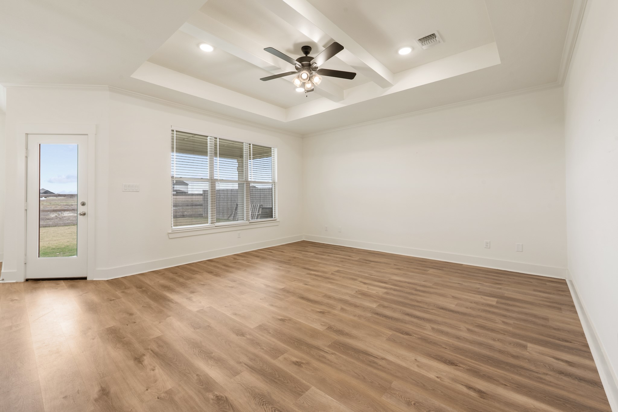 424 Brazos Bend Snook, TX 77879 - Photo 3 of 23 an empty room with wooden floor chandelier fan and windows