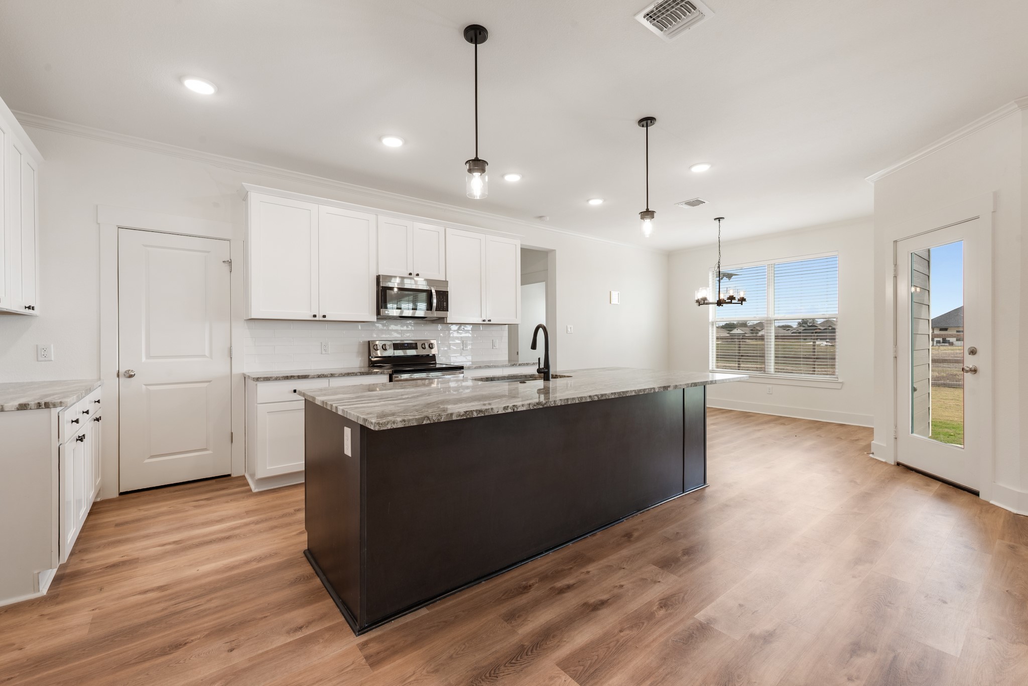 424 Brazos Bend Snook, TX 77879 - Photo 6 of 23 a large kitchen with stainless steel appliances granite countertop a refrigerator a sink dishwasher a stove and a wooden floor