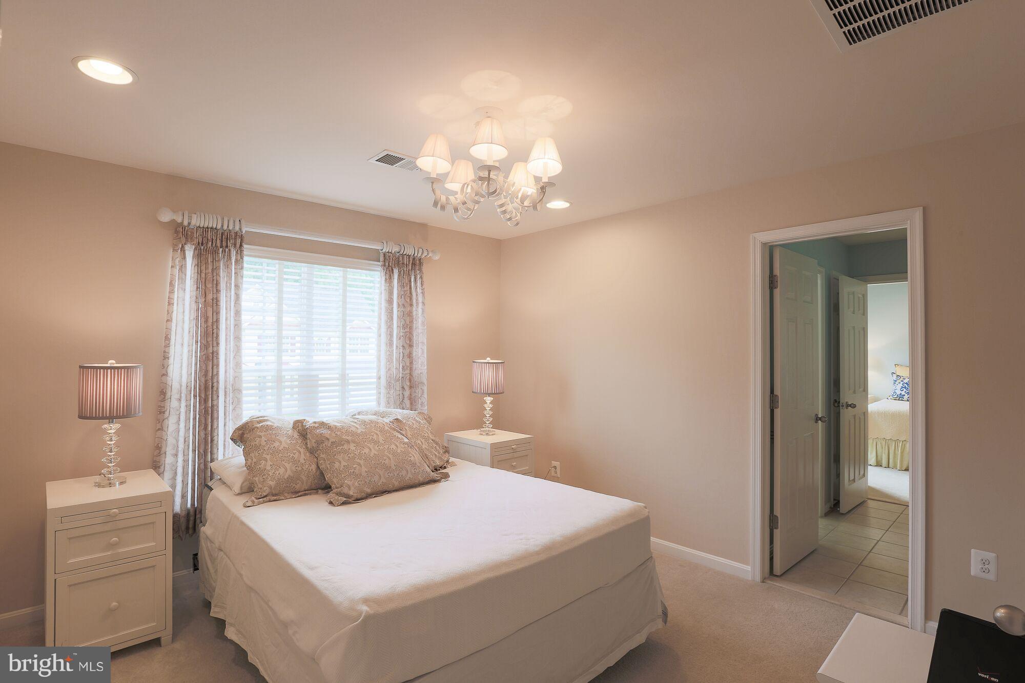 6524 Pebble Brooke Road Baltimore, MD 21209 - Photo 16 of 20 a bedroom with a bed and a chandelier