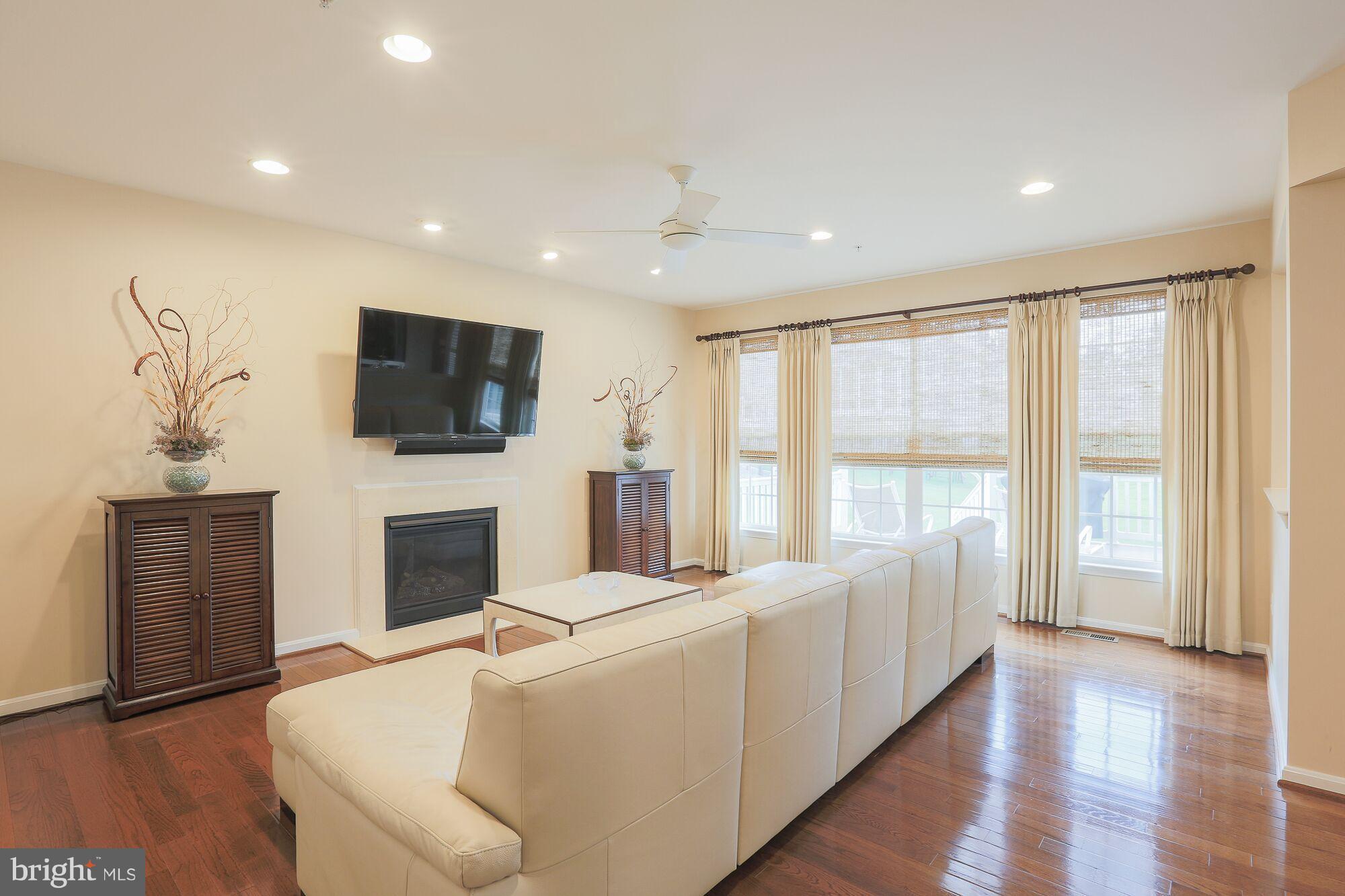 6524 Pebble Brooke Road Baltimore, MD 21209 - Photo 9 of 20 a living room with furniture a flat screen tv and a fireplace