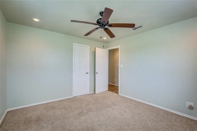 a view of a livingroom with a ceiling fan & window