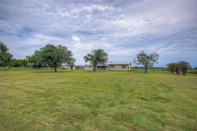 a view of yard with swimming pool and green space