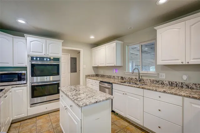 a kitchen with stainless steel appliances granite countertop a stove sink and cabinets