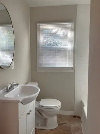 a bathroom with a sink toilet and a mirror