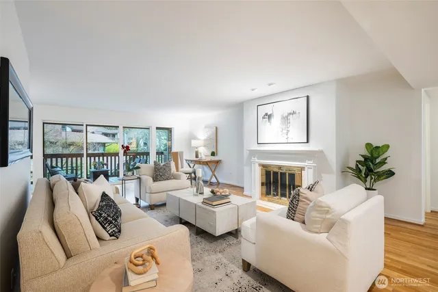 a living room with furniture large window and wooden floor
