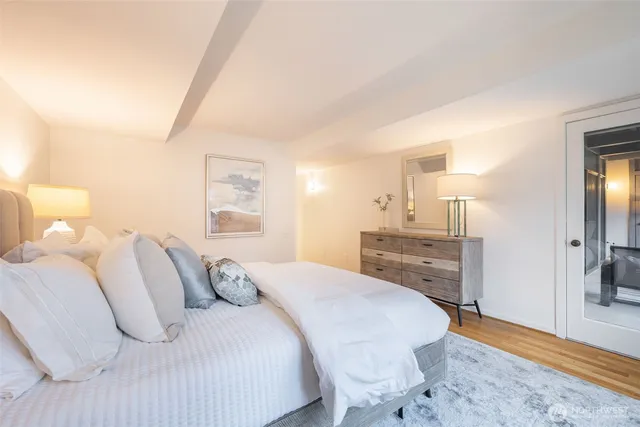 a spacious bedroom with a bed and wooden floor