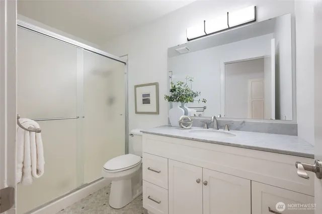 a bathroom with a granite countertop sink a toilet and a mirror