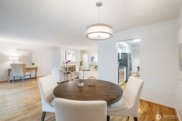 a dining room with wooden floor a chandelier a wooden table and chairs