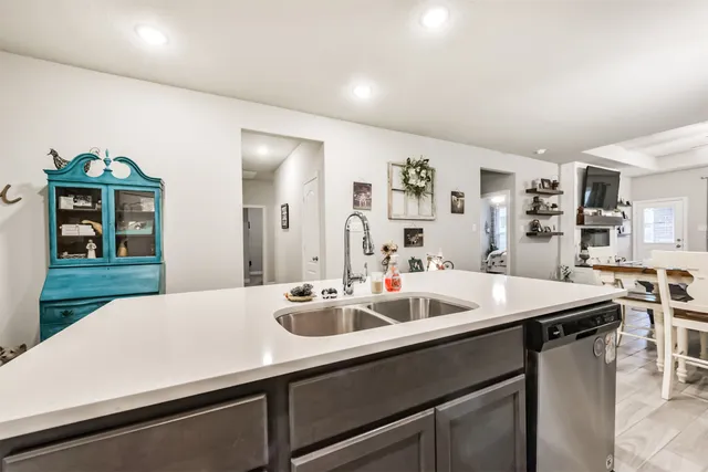 a view of a kitchen island a sink and wooden floor