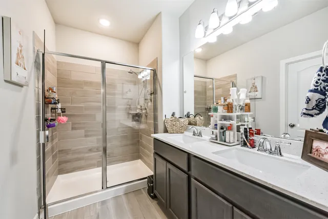 a bathroom with a double vanity sink mirror and shower