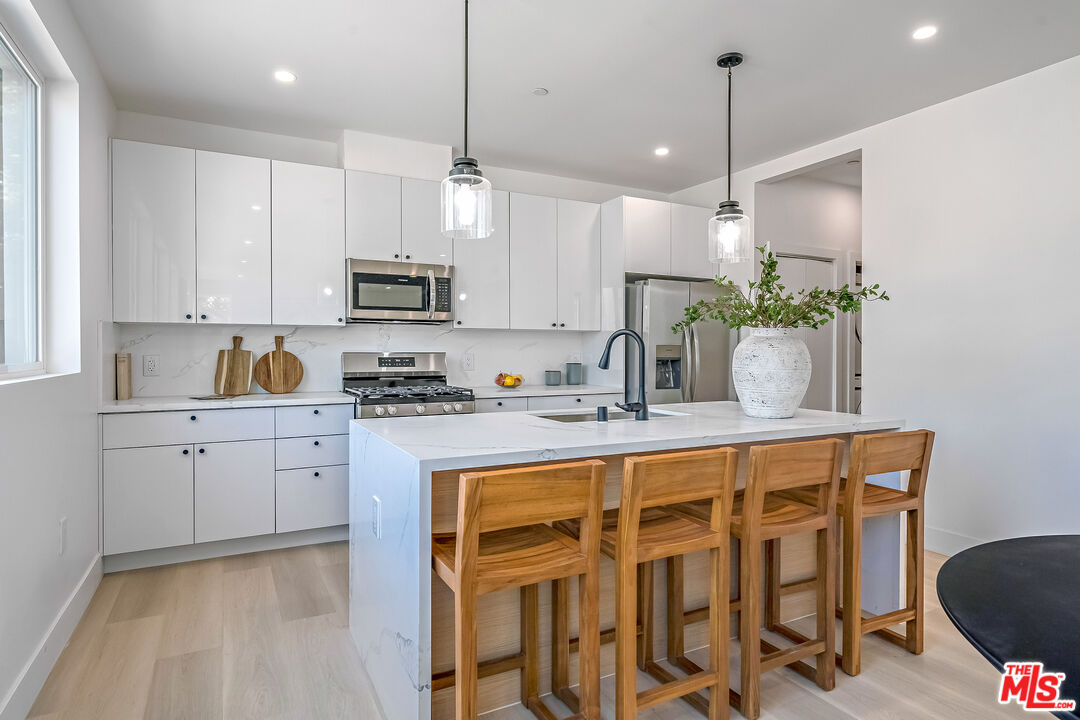 5832 David Avenue, Unit 1 Los Angeles, CA 90034 - Photo 13 of 44 a kitchen with a table chairs stove and cabinets