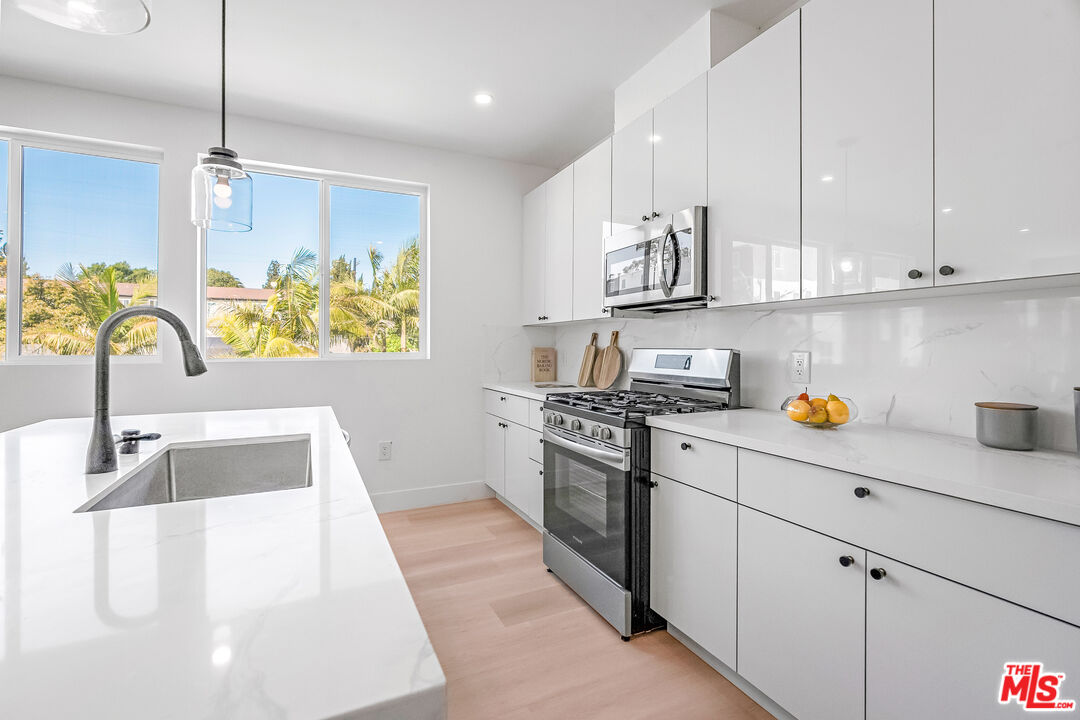 5832 David Avenue, Unit 1 Los Angeles, CA 90034 - Photo 14 of 44 a kitchen with stainless steel appliances granite countertop a sink a stove and a refrigerator