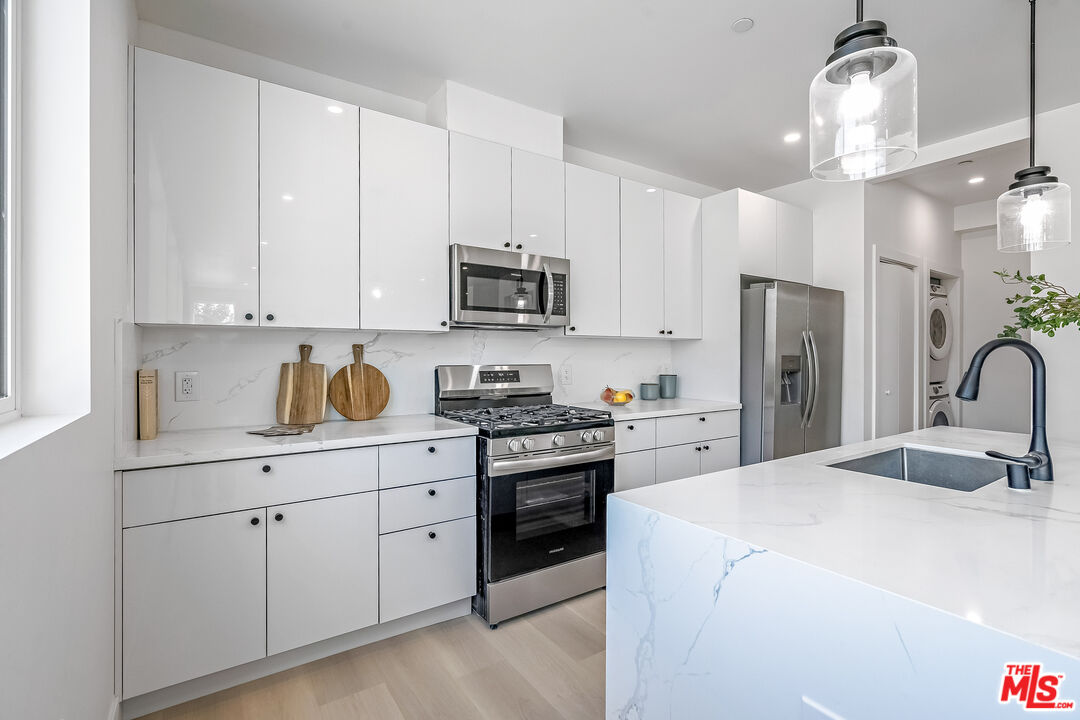 5832 David Avenue, Unit 1 Los Angeles, CA 90034 - Photo 16 of 44 a kitchen with stainless steel appliances granite countertop a refrigerator a stove a sink and white cabinets