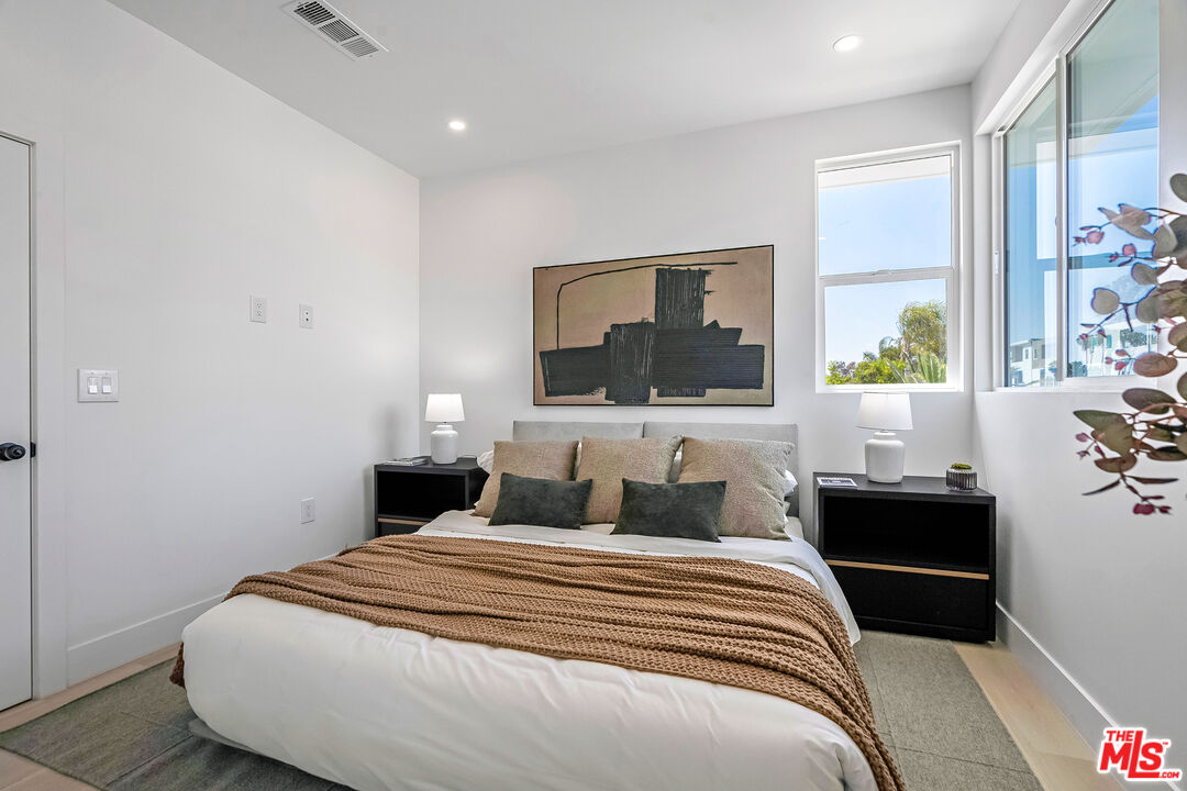 5832 David Avenue, Unit 1 Los Angeles, CA 90034 - Photo 23 of 44 a bedroom with a large bed and wooden floor