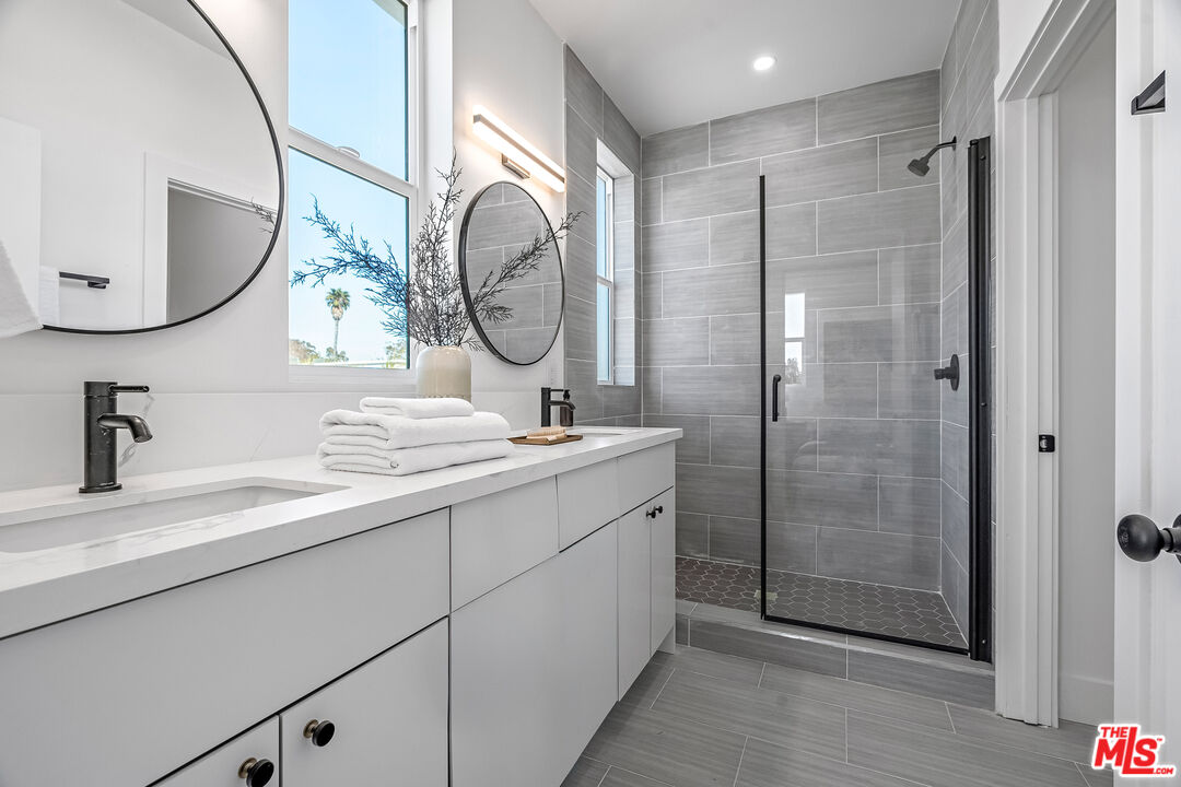 5832 David Avenue, Unit 1 Los Angeles, CA 90034 - Photo 25 of 44 a bathroom with a double vanity sink mirror and shower