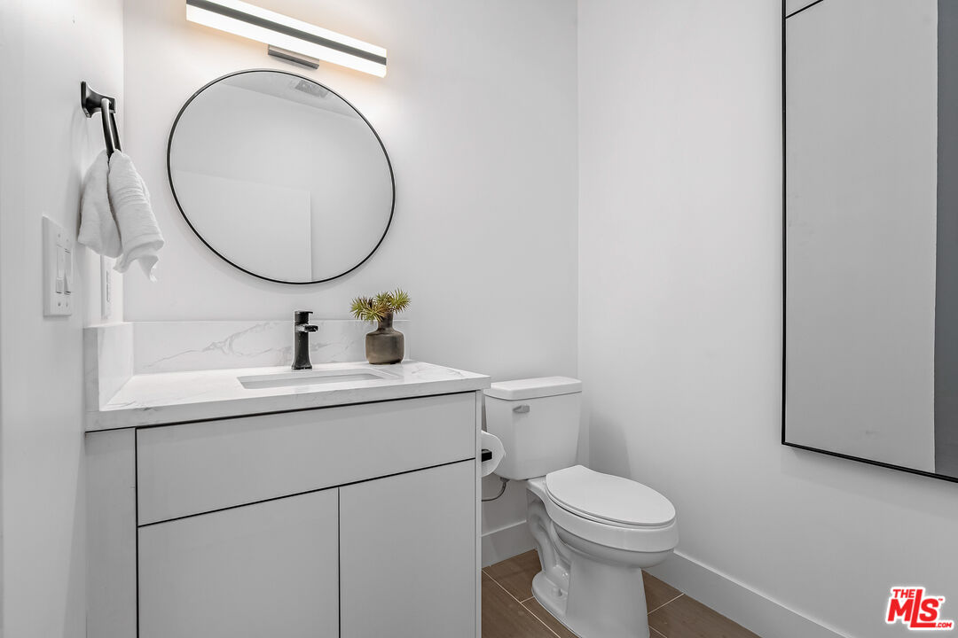 5832 David Avenue, Unit 1 Los Angeles, CA 90034 - Photo 33 of 44 a bathroom with a sink mirror vanity and toilet