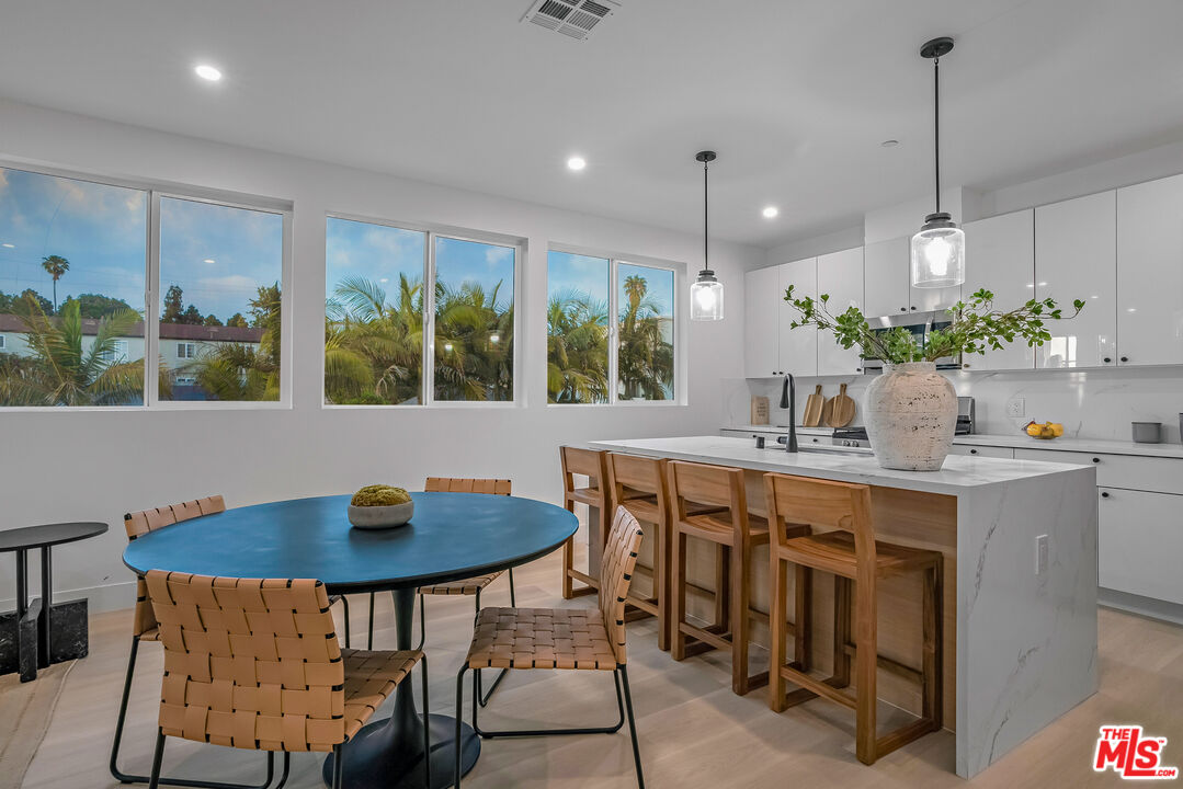 5832 David Avenue, Unit 1 Los Angeles, CA 90034 - Photo 38 of 44 a kitchen with a table chairs and white cabinets