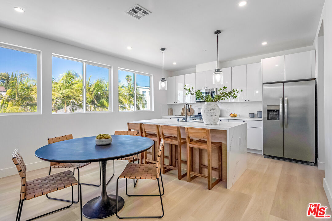 5832 David Avenue, Unit 1 Los Angeles, CA 90034 - Photo 10 of 44 a kitchen with stainless steel appliances granite countertop a table chairs stove and refrigerator