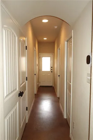 a view of a hallway with wooden floor and windows
