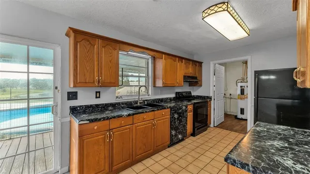 a kitchen with stainless steel appliances granite countertop a stove a sink and a refrigerator