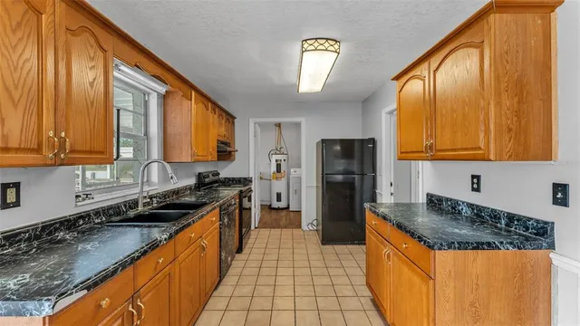 a kitchen with stainless steel appliances granite countertop a stove a sink a refrigerator and a granite counter tops