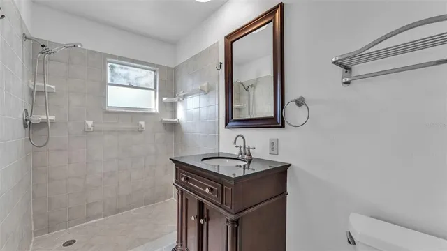 a bathroom with a granite countertop sink toilet and shower