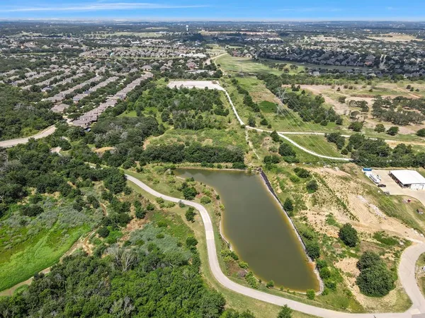 an aerial view of residential houses with outdoor space and trees