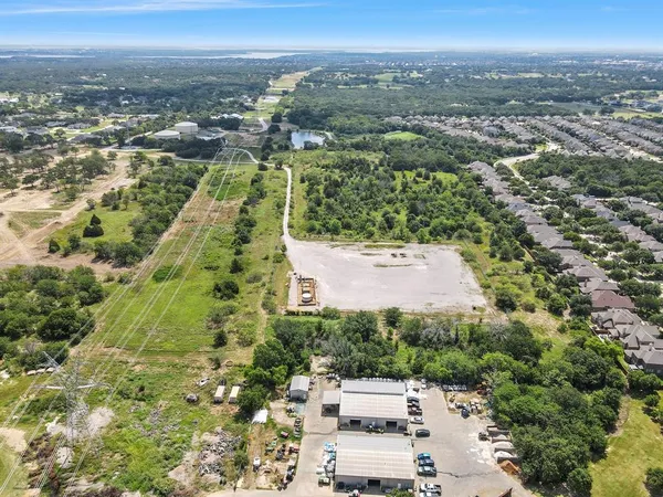 an aerial view of residential houses with outdoor space and trees