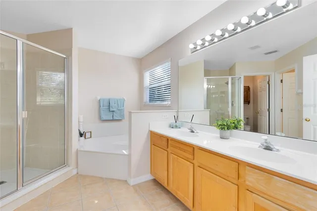 a spacious bathroom with a double vanity sink mirror and bathtub