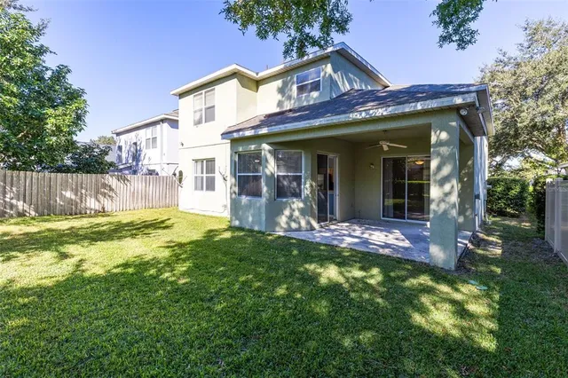 a view of a house with a small yard and large tree