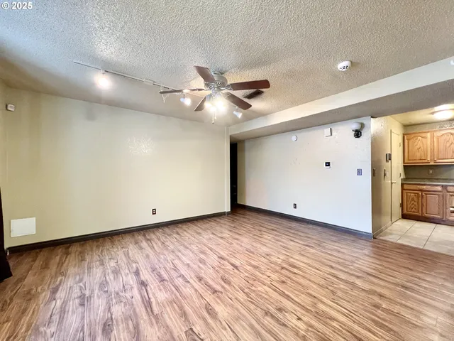 a view of a livingroom with a ceiling fan wooden floor and a ceiling fan