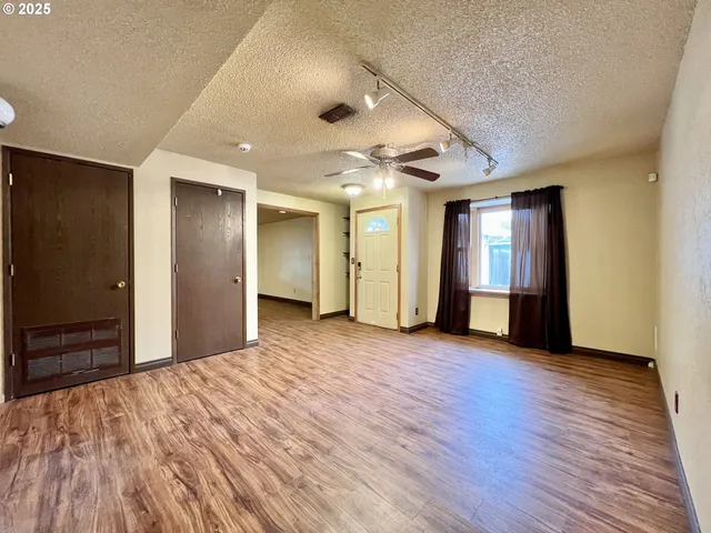 a view of empty room with wooden floor