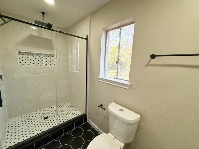 a bathroom with a shower toilet and sink