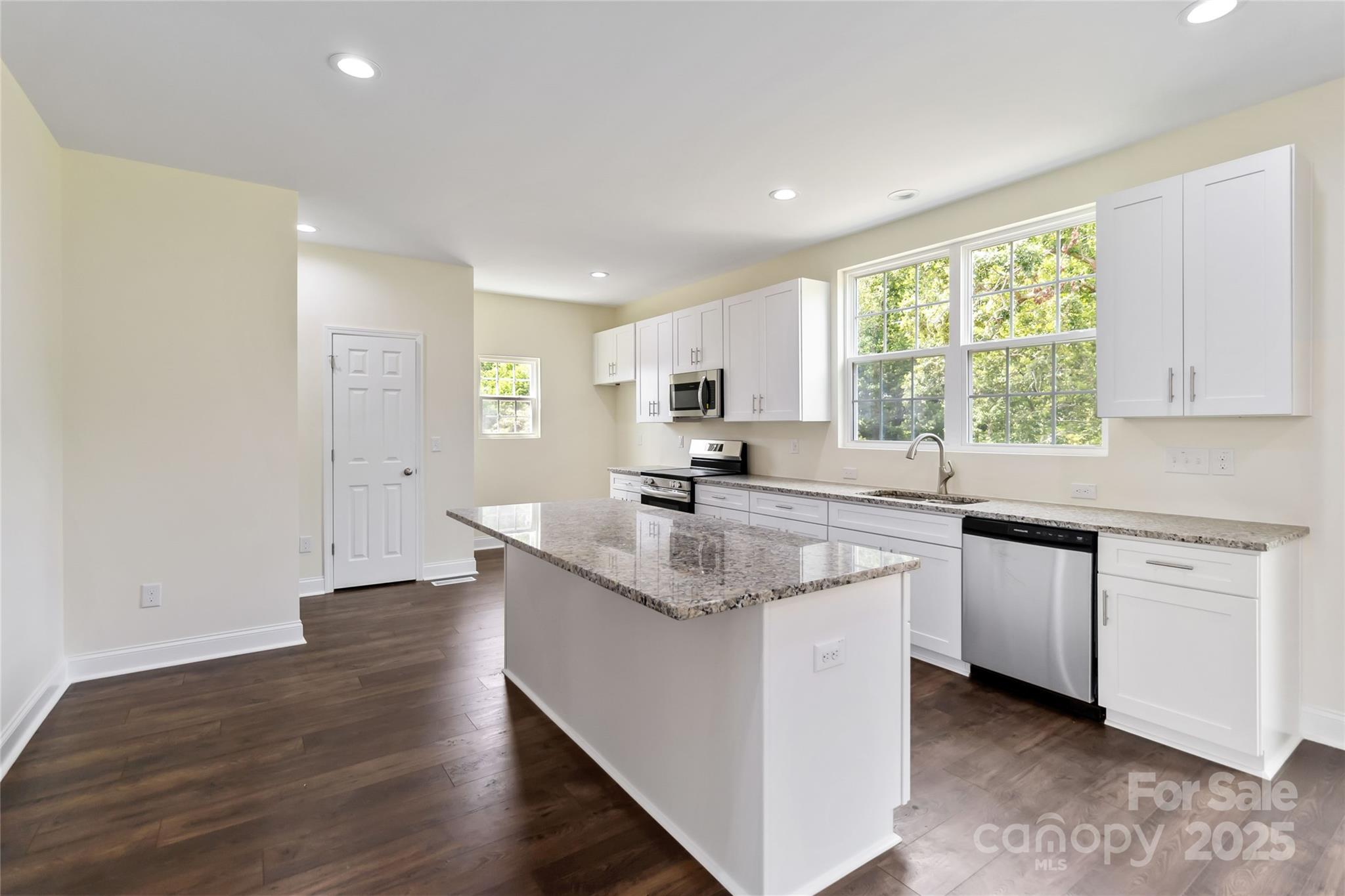 1034 Heath Helms Road Monroe, NC 28110 - Photo 11 of 30 a kitchen with stainless steel appliances granite countertop a sink stove and refrigerator