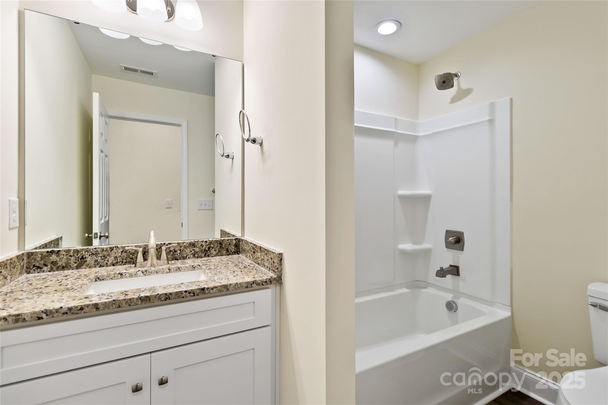 1034 Heath Helms Road Monroe, NC 28110 - Photo 24 of 30 a bathroom with a granite countertop tub sink and mirror
