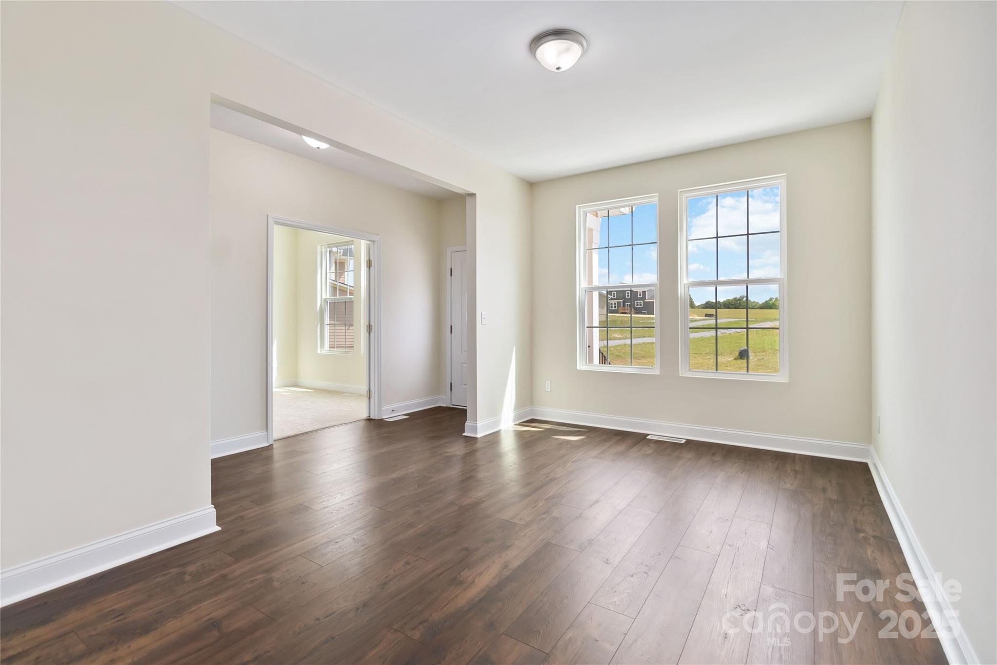 1034 Heath Helms Road Monroe, NC 28110 - Photo 6 of 30 an empty room with wooden floor and windows