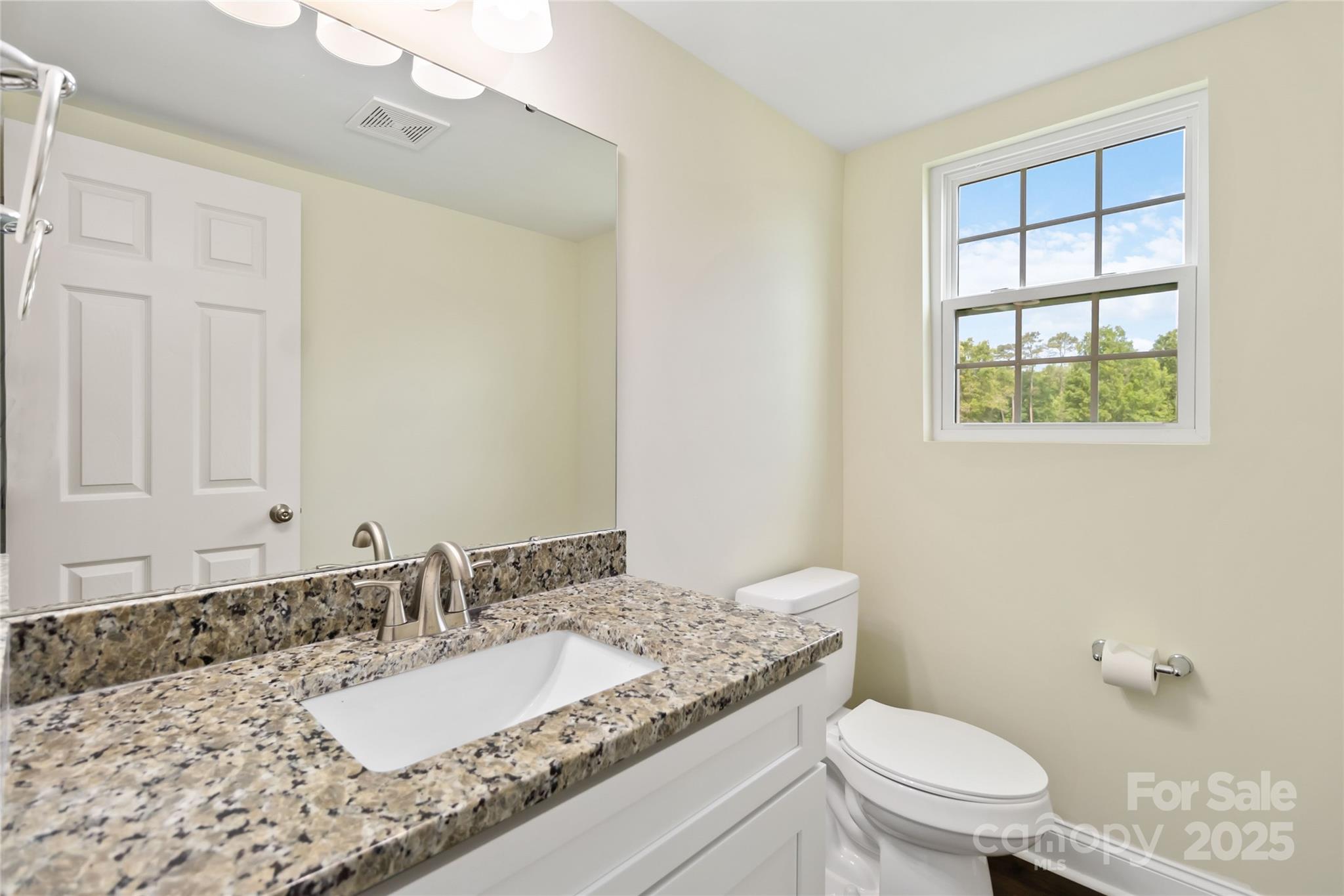 1034 Heath Helms Road Monroe, NC 28110 - Photo 7 of 30 a bathroom with a granite countertop sink a mirror and a toilet