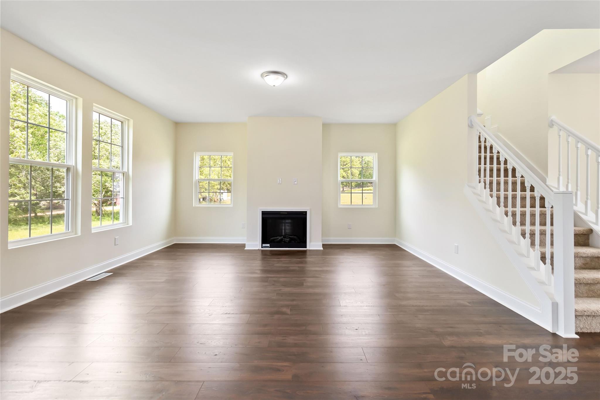 1034 Heath Helms Road Monroe, NC 28110 - Photo 9 of 30 an empty room with wooden floor and windows