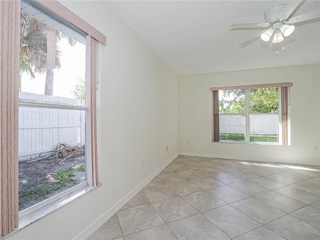 a view of empty room with window and fan