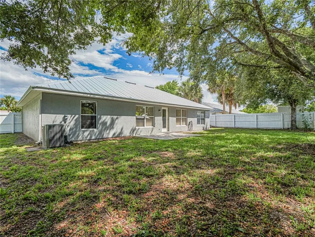 a backyard of a house with table and chairs