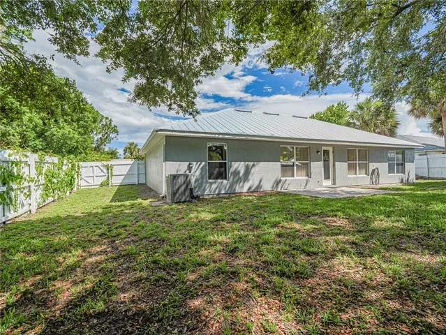 a view of a house with a backyard and a tree