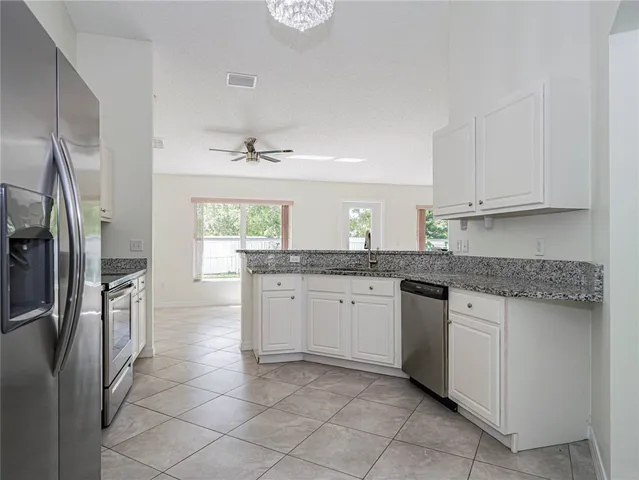 a kitchen with stainless steel appliances granite countertop a sink and a refrigerator