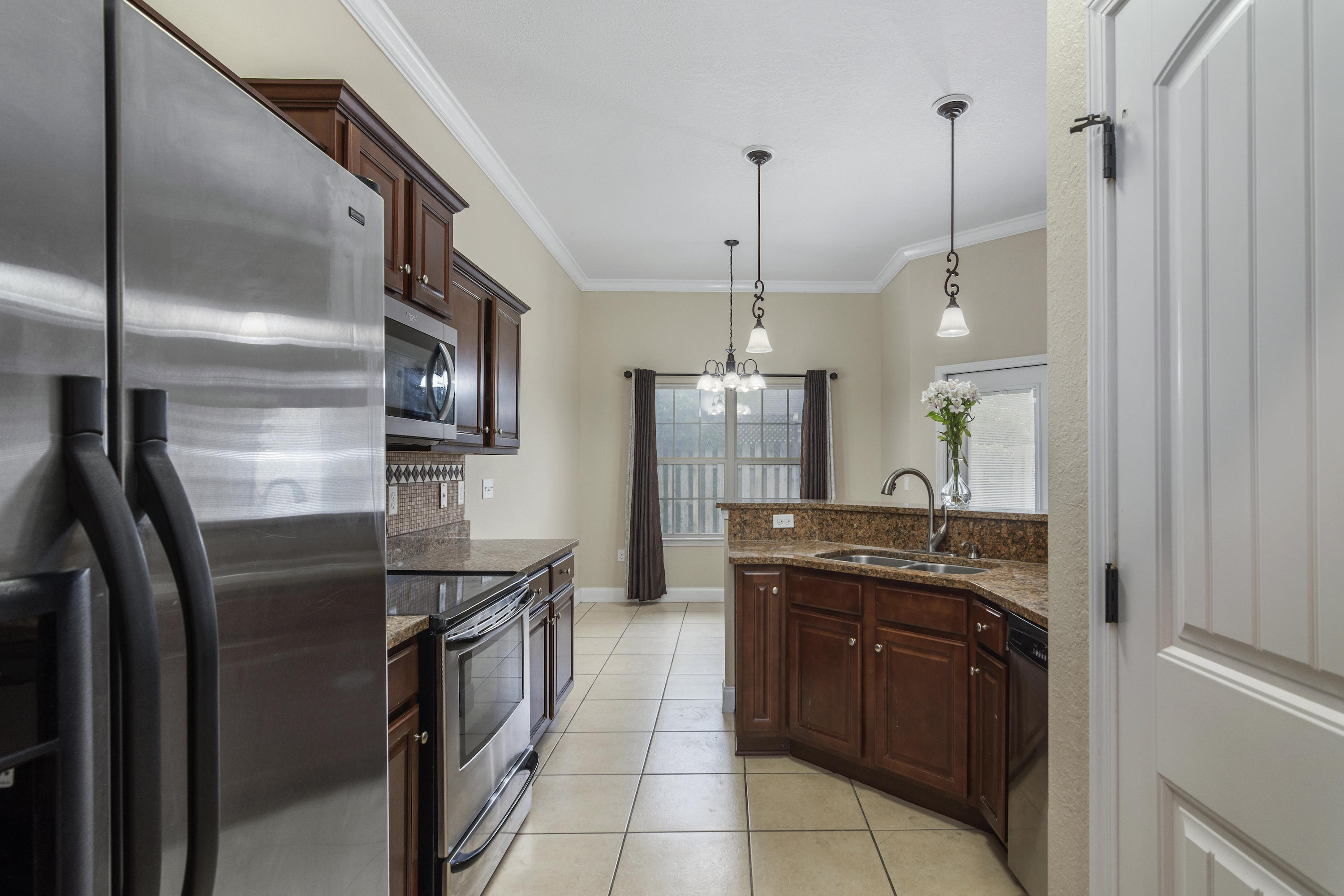 4610 Hermosa Road Crestview, FL 32539 - Photo 12 of 35 a kitchen with stainless steel appliances granite countertop a stove a refrigerator and a sink