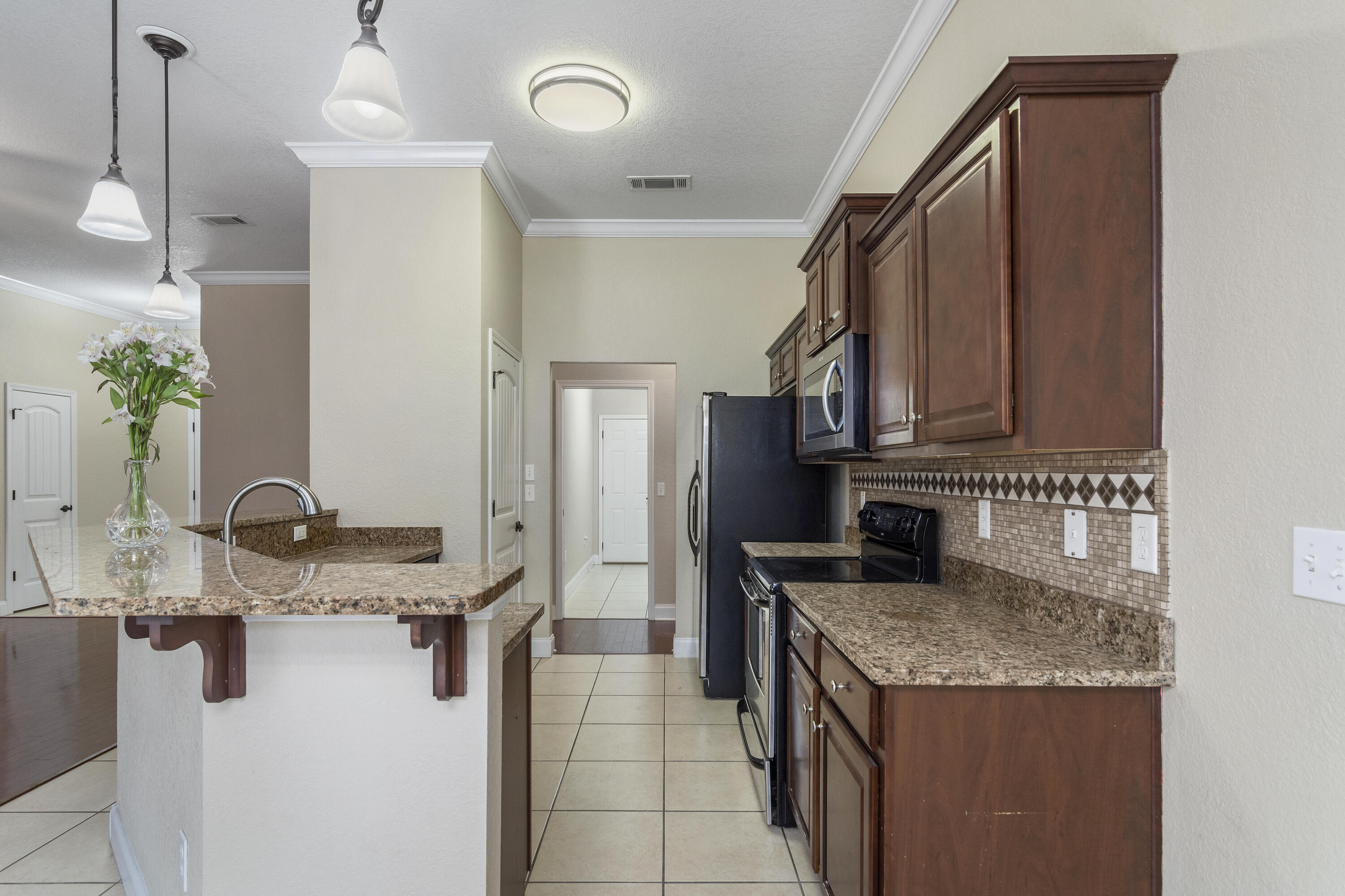 4610 Hermosa Road Crestview, FL 32539 - Photo 10 of 35 a kitchen with stainless steel appliances granite countertop a sink stove and refrigerator