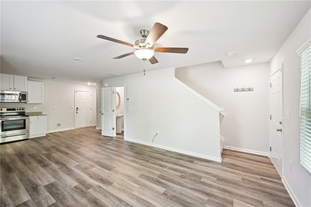 4437 Ben Hill Road Atlanta, GA 30349 - Photo 4 of 40 a view of an empty room with wooden floor and a ceiling fan