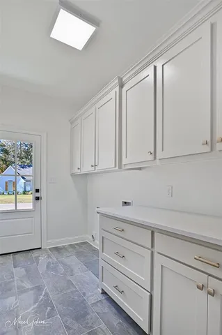 a view of an empty room with cabinet and entryway