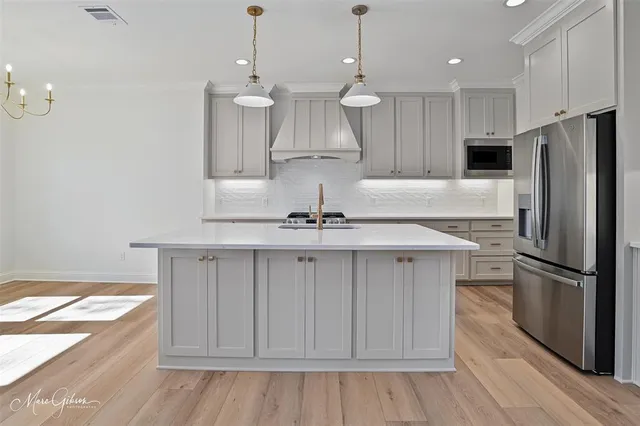 a kitchen with kitchen island a sink and a stove