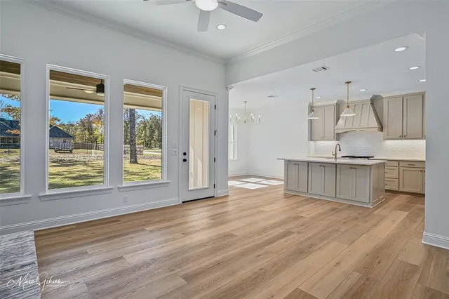 a view of an empty room with wooden floor fireplace and a window