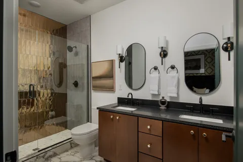 a bathroom with a granite countertop sink mirror toilet and shower
